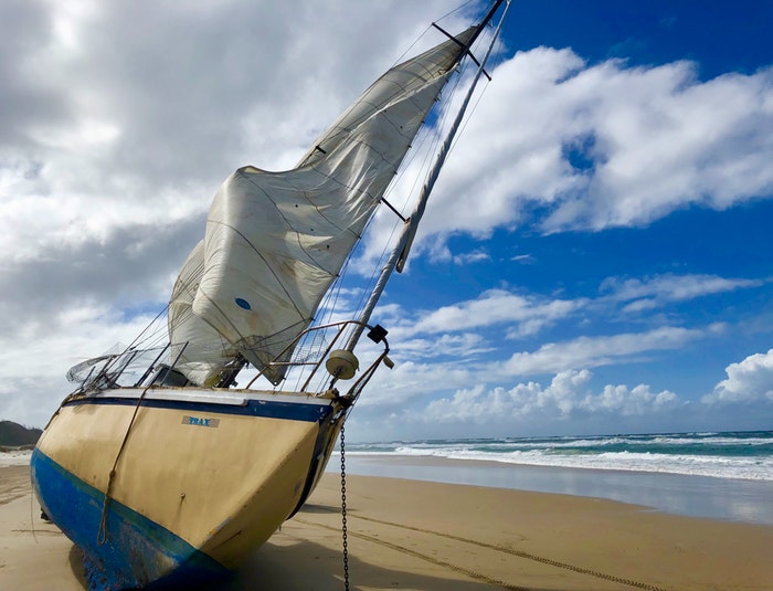 white-sail-boat-on-beach